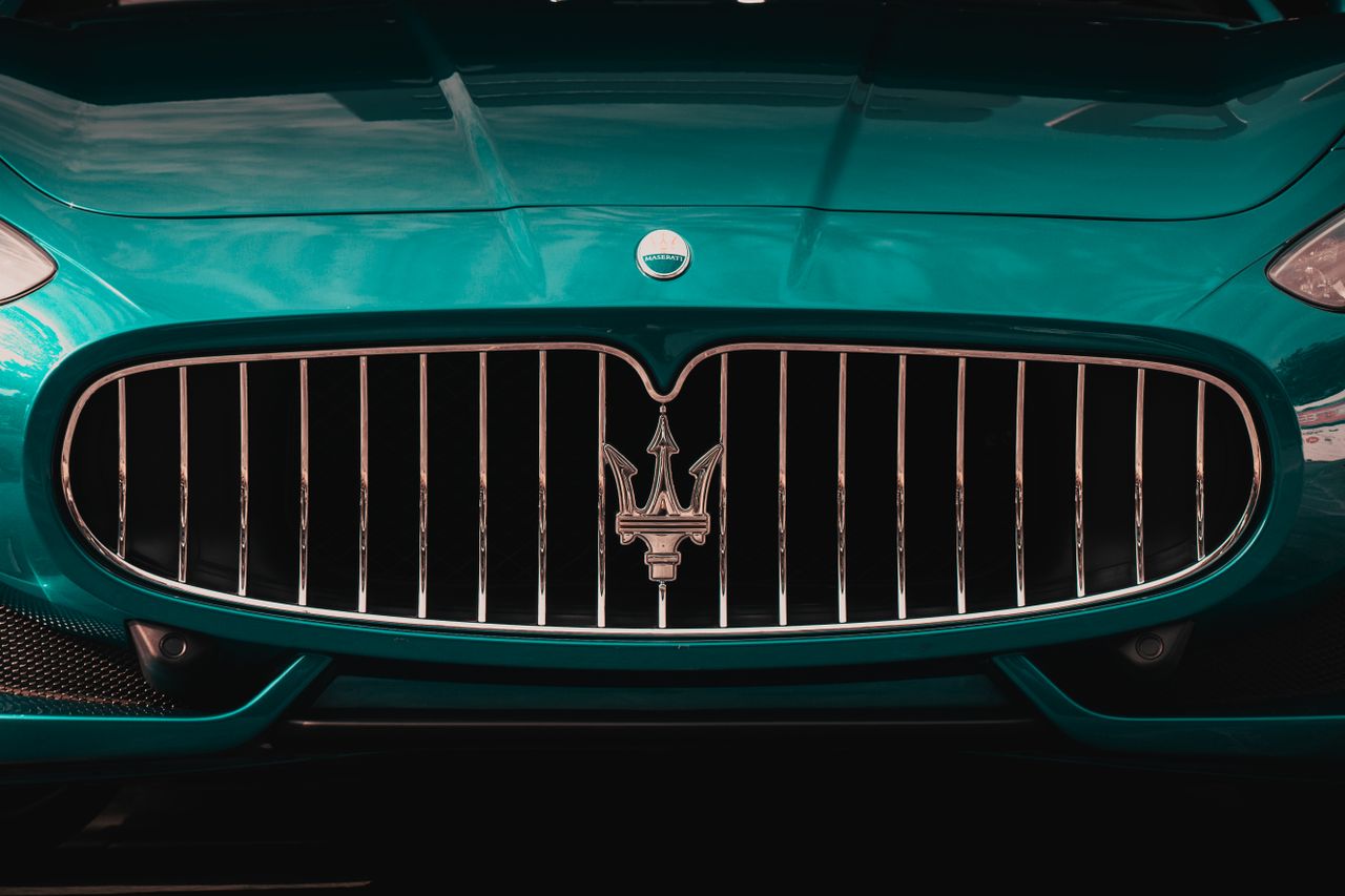 Close-up of a sleek Maserati car grille showcasing luxury and style.